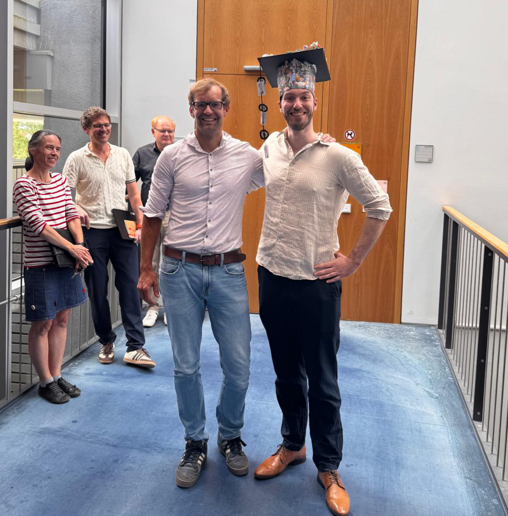 Felix defended his thesis. A picture with Christof Osman and Felix Thoma wearing his PhD hat.